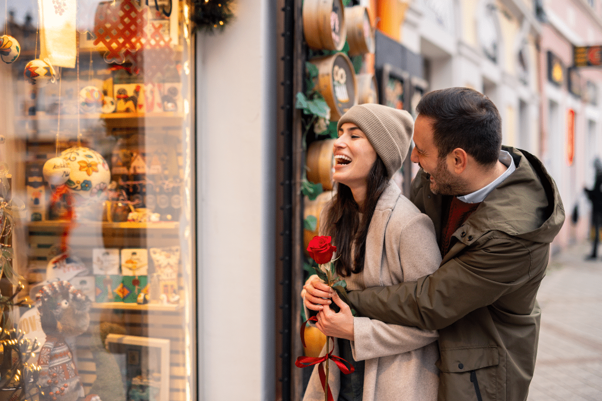 A couple hugging and laughing outside a shop