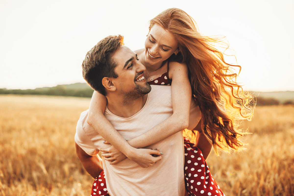 phases of a romantic relationship Homme porte sa compagne sur son dos et tous deux profitent de ce moment ensemble à la campagne
