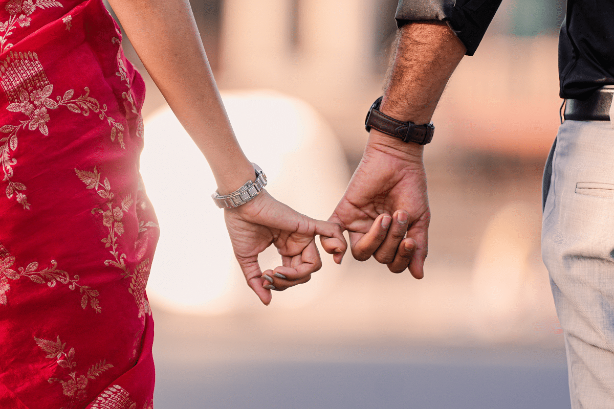 signs your relationship will last Couple holding hands, with their fingers intertwined, symbolising a lasting relationship