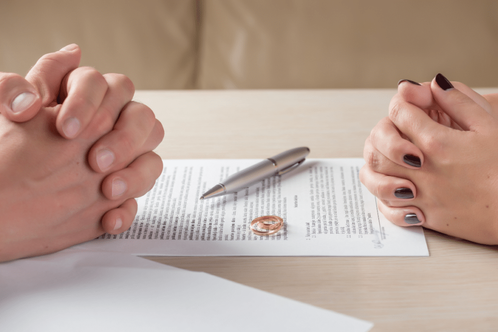 The hands of the wife and husband signing a divorce agreement